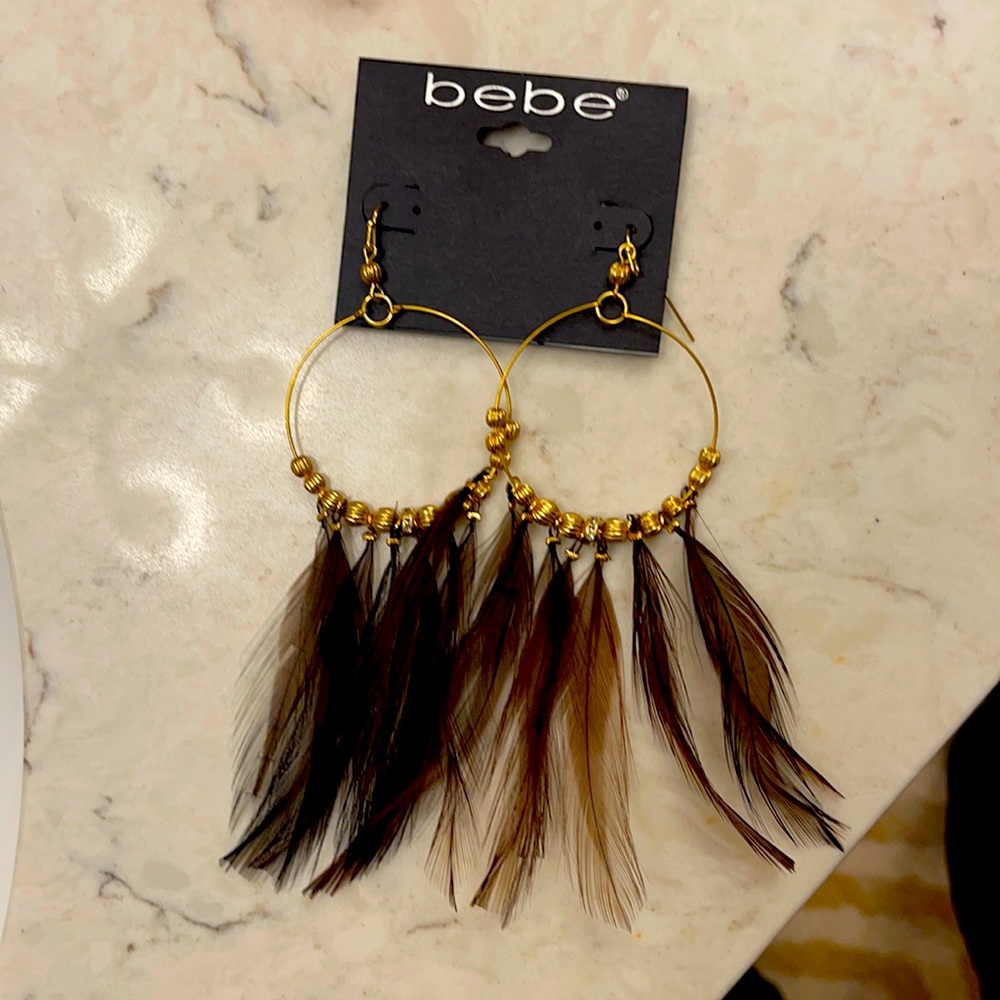 Gold colored earrings with feathers